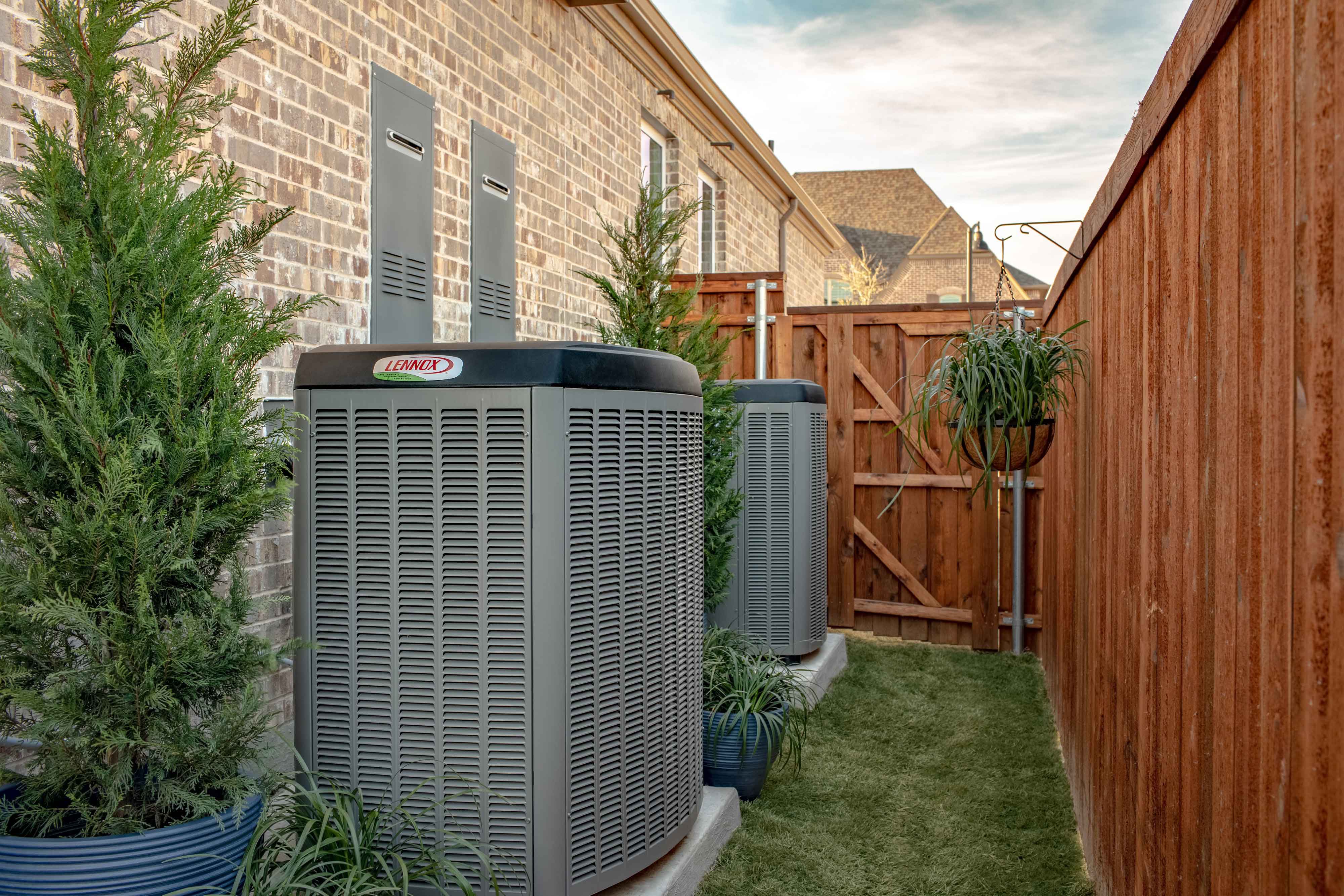 Lennox outdoor unit installed in a well-maintained backyard with landscaping